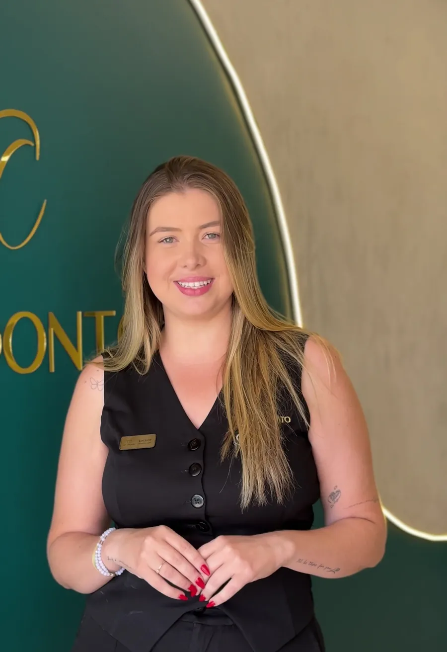 Parede verde com o arco iluminado e o logo dourado da Col Odonto